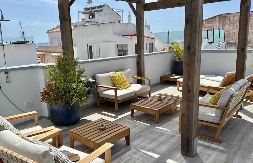 a patio with chairs and tables on a roof at My Residence Alvor in Alvor