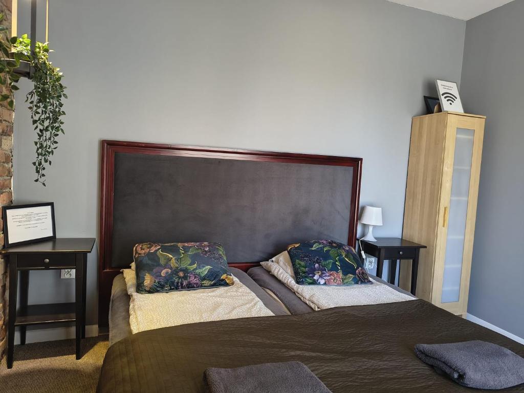 a bedroom with a bed with two pillows on it at Flores Apartament in Katowice