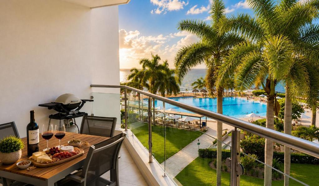 a balcony with a table and a view of a pool at Aria Ocean in Nuevo Vallarta