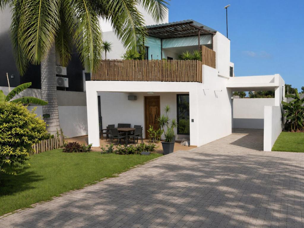 a white house with palm trees and a driveway at Casa Mangrove in Maputo