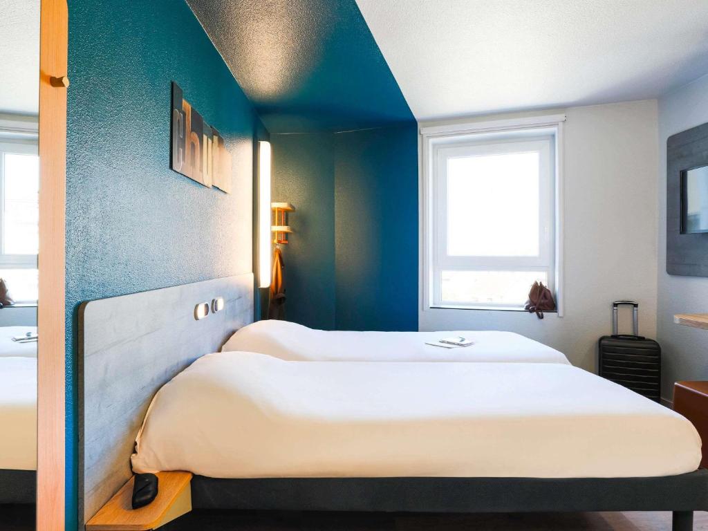 two beds in a room with blue walls at ibis budget Bordeaux Centre - Gare Saint Jean in Bordeaux