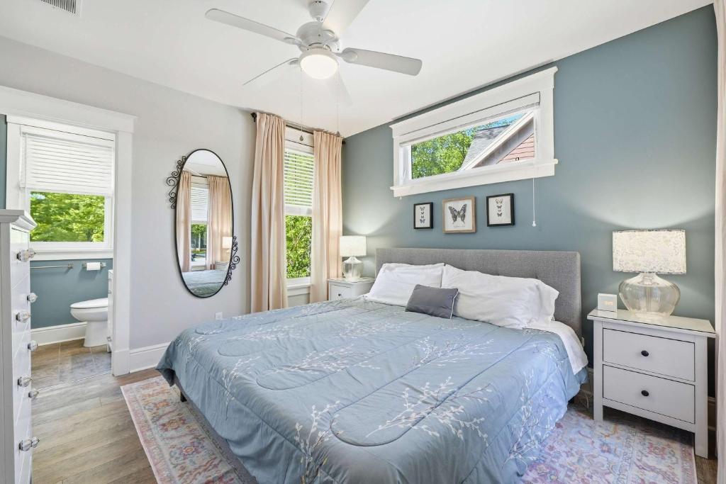 a blue bedroom with a bed and a mirror at The Jackrabbit - 3 Summer Village in Cherry Valley