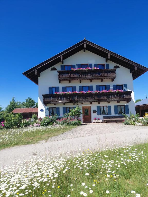 a white building with flowers in front of it at Asbichlerhof in Bad Endorf