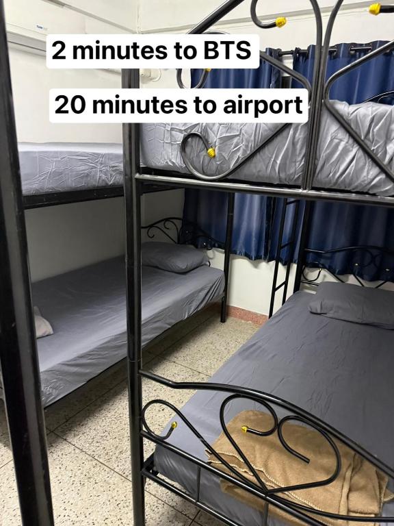 a room with two bunk beds and the words minutes to bts minutes at W District hostel in Bangkok