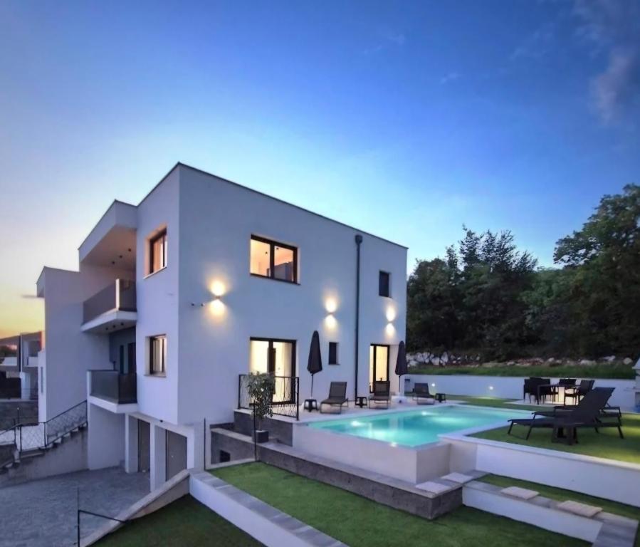 a large white house with a swimming pool at Lux Villa Dijana - Privat Infinity Pool-Jacuzzi-Sea view in Kostrena