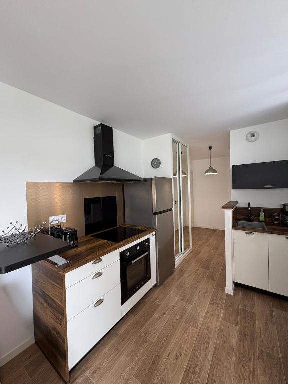 a kitchen with white cabinets and a stove top oven at Studio with garden in Dinard