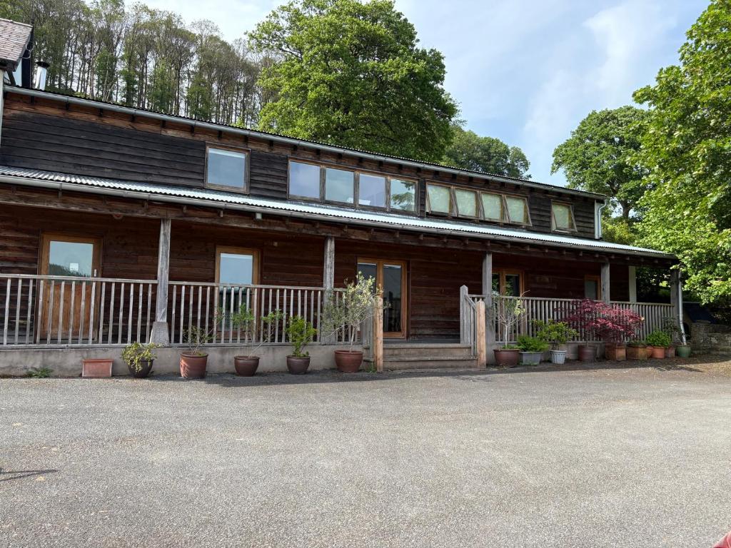 a wooden house with potted plants in front of it at Willow Cottage in Presteigne