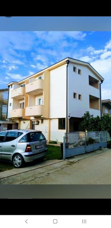 a car parked in front of a building at Apartman Almira in Donji Štoj