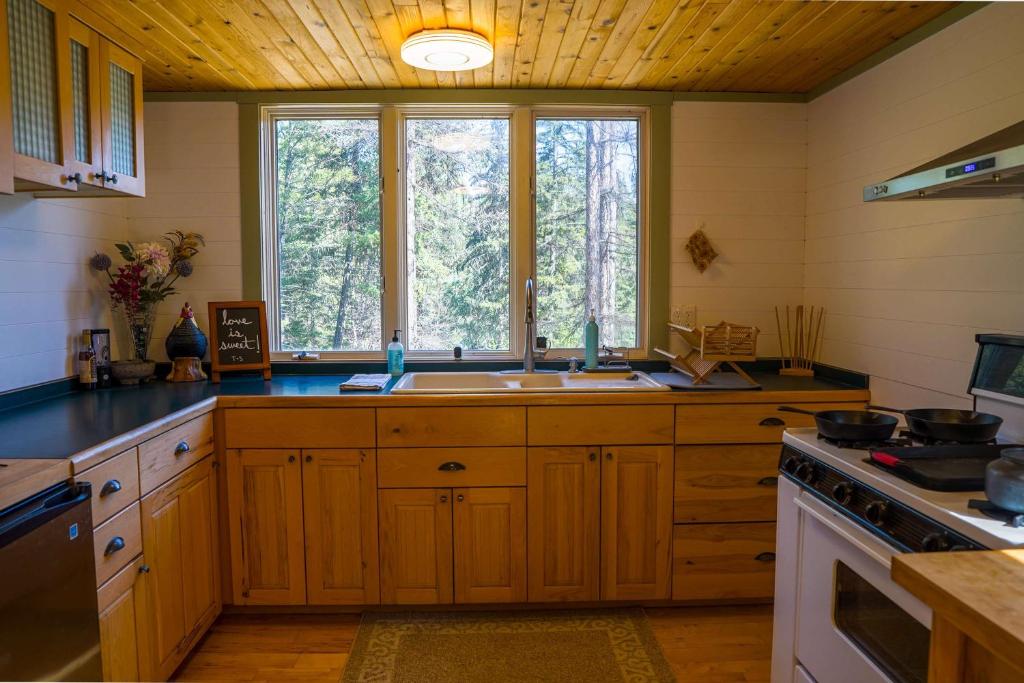 a kitchen with a sink and a large window at Off Grid Retreat Stay for 7 in Rexford