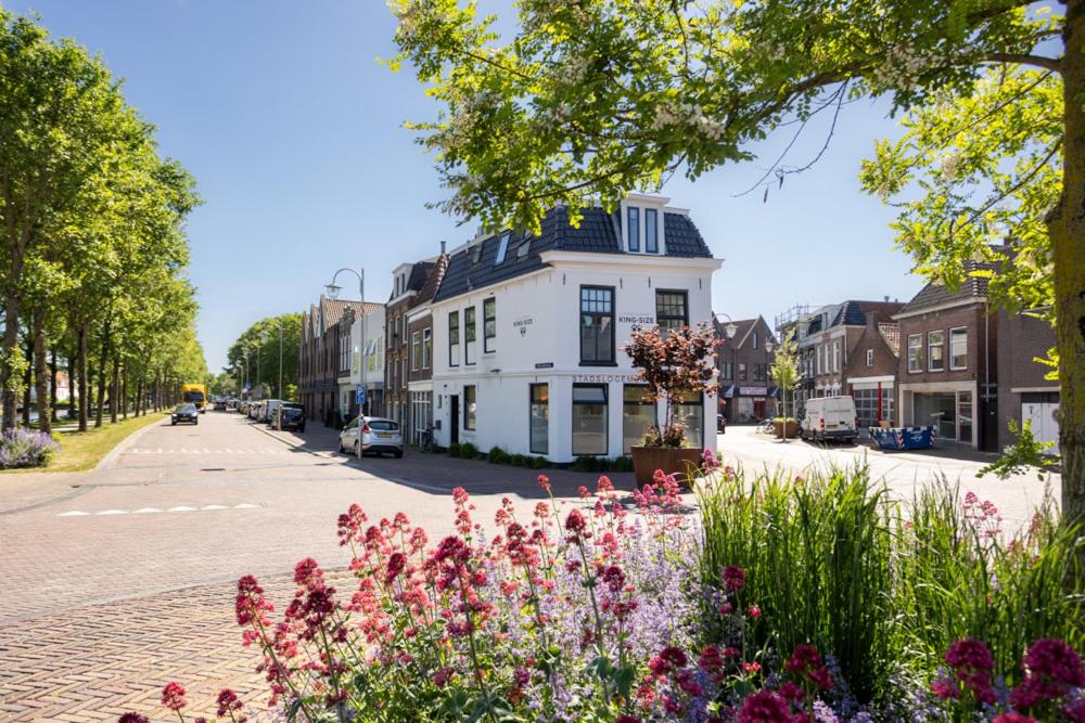 a street with flowers in front of a white house at Stadslogement Kingsize in Sneek