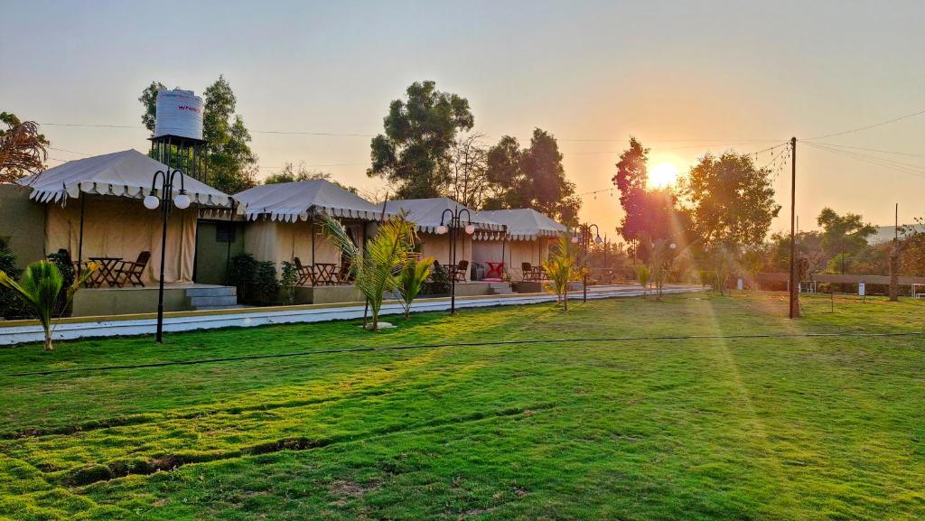 a resort with a green lawn in front of a building at Whispering Woods in Gorthan
