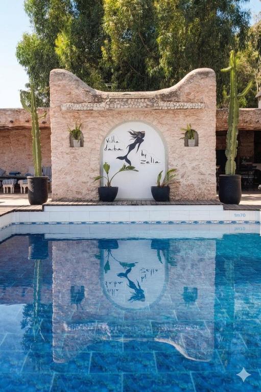 a sign that is next to a swimming pool at Villa Daba By Zelia in Ghazoua