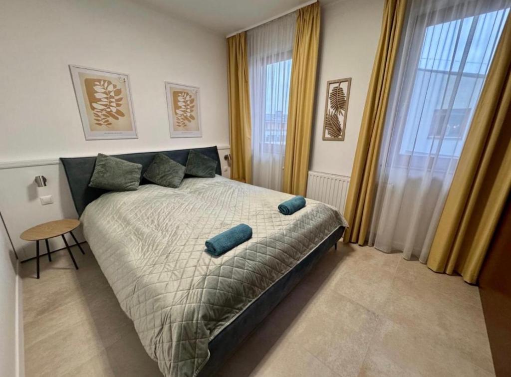 a bedroom with a bed with blue pillows on it at Lavén Superior Apartment in Balatonfüred