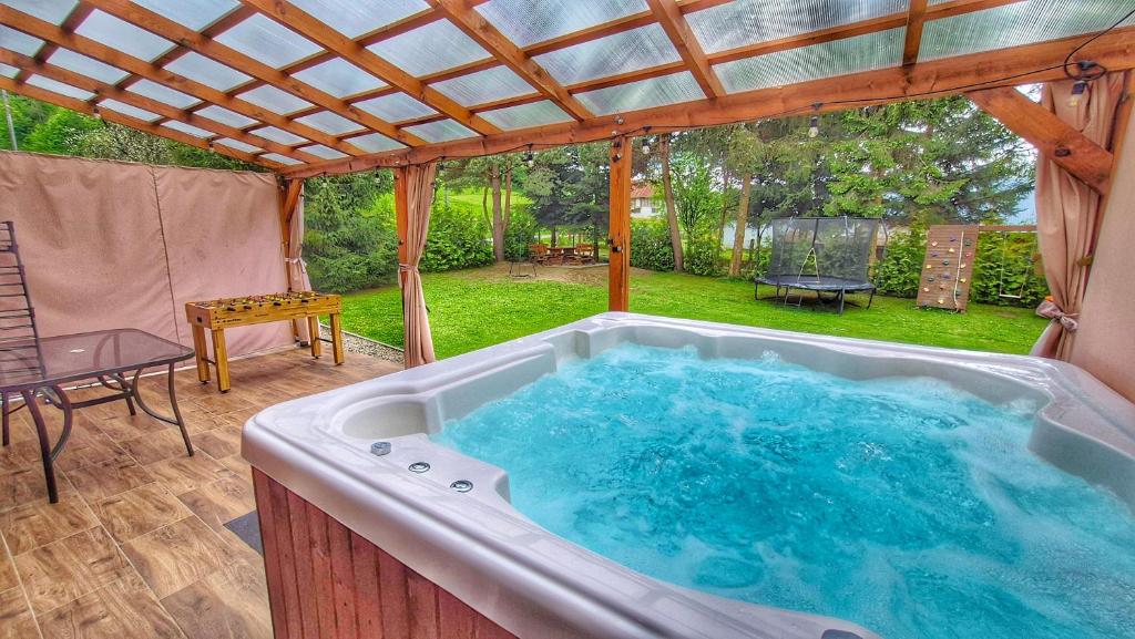 a jacuzzi tub in the middle of a patio at Urocza Kryjówka ze SPA in Lesko