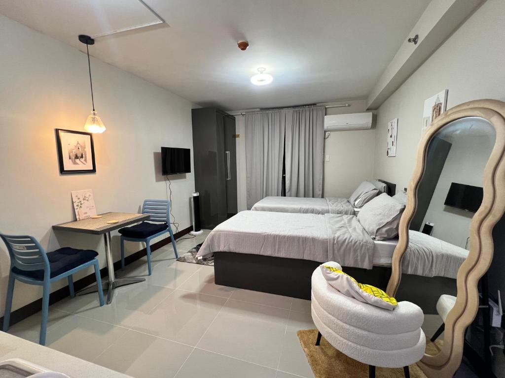 a bedroom with a bed and a mirror and a desk at JIYA Studio and Breakfast in Cebu City