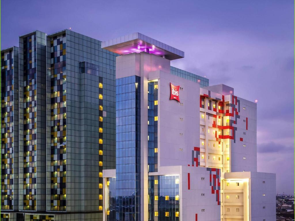 a tall building with a canadian flag on it at Ibis Jakarta Harmoni in Jakarta