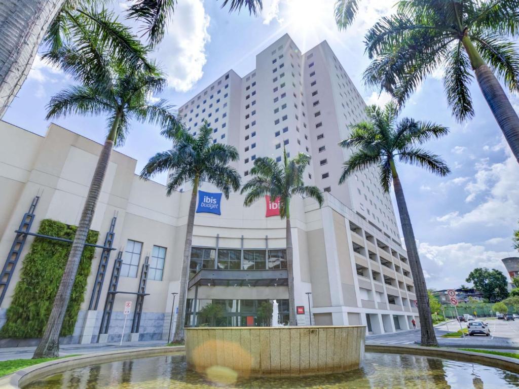 a building with palm trees in front of it at ibis Rio de Janeiro Nova America in Rio de Janeiro