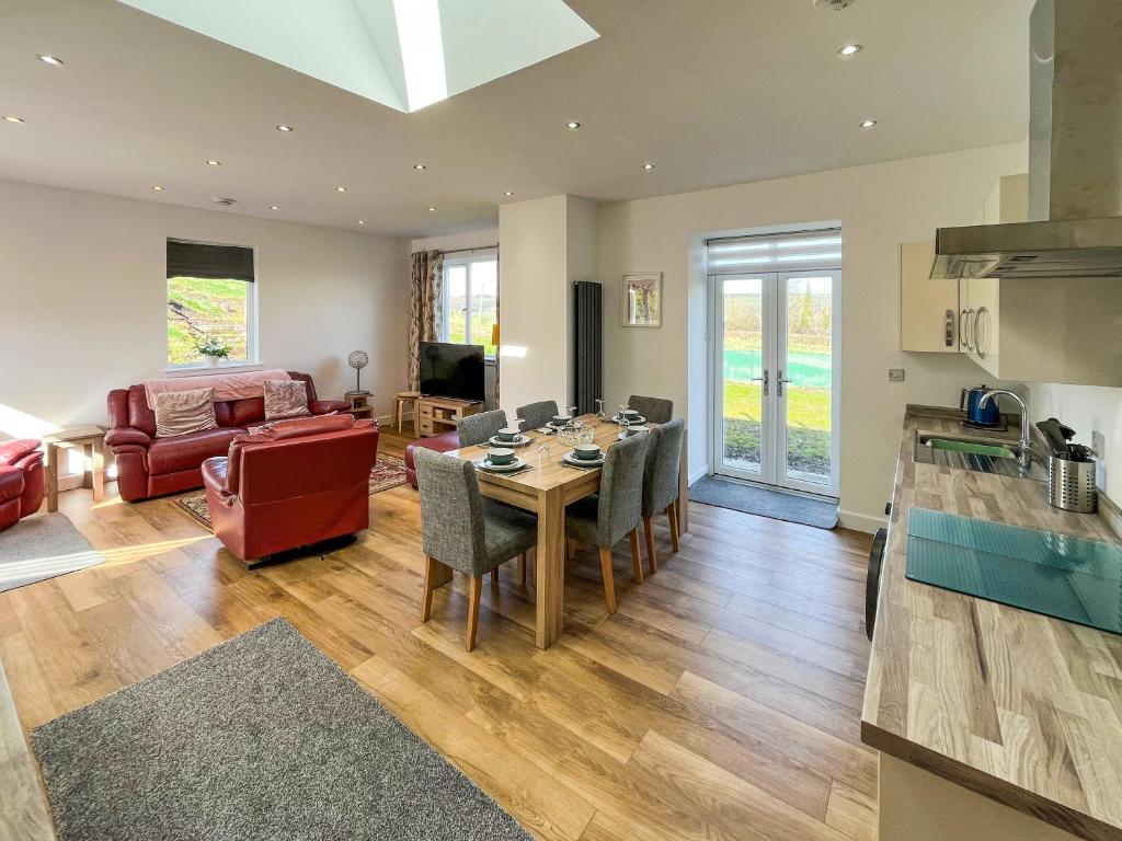a kitchen and living room with a table and chairs at North Lodge in Forgandenny