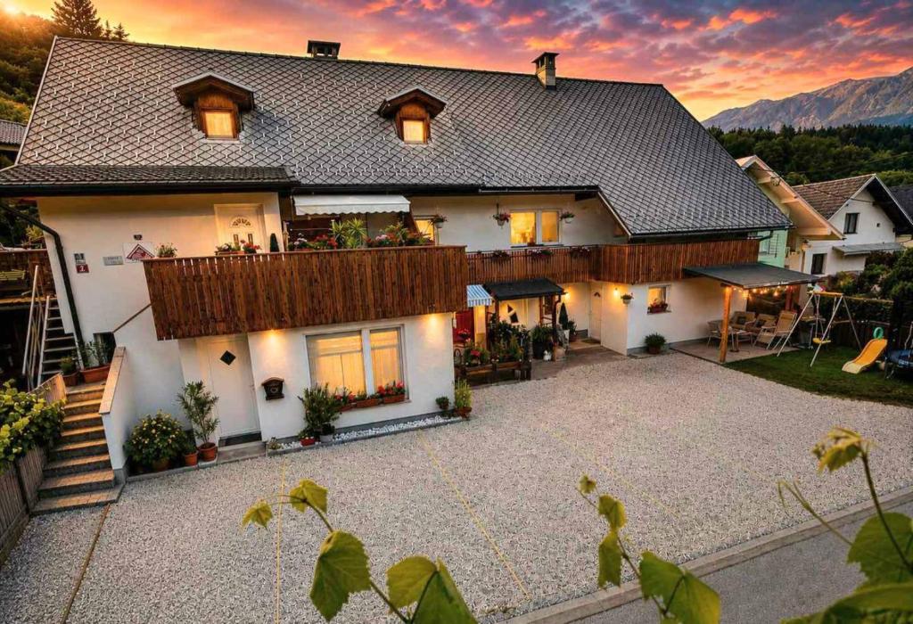 een groot wit huis met een groot terras bij Apartments Karin in Bled