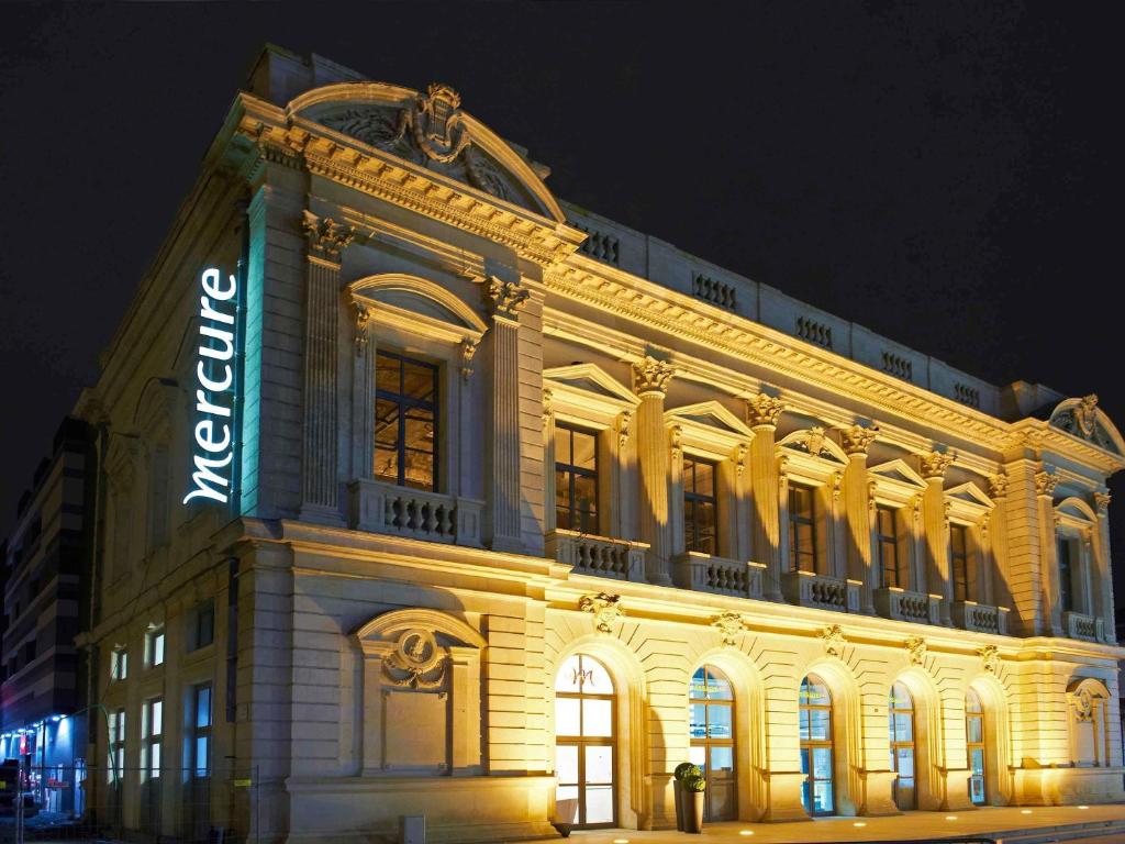a building with a neon sign on the side of it at Mercure Cholet Centre in Cholet