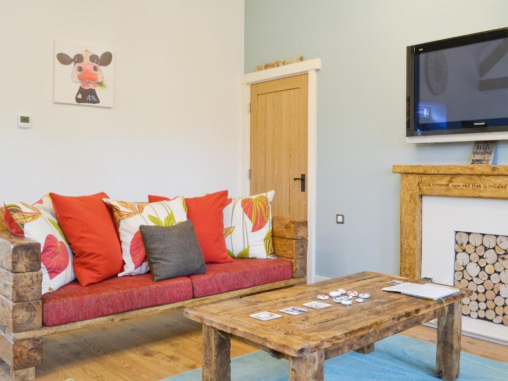 a living room with a red couch and a coffee table at 'Ow Do - Uk11446 in Skipsea