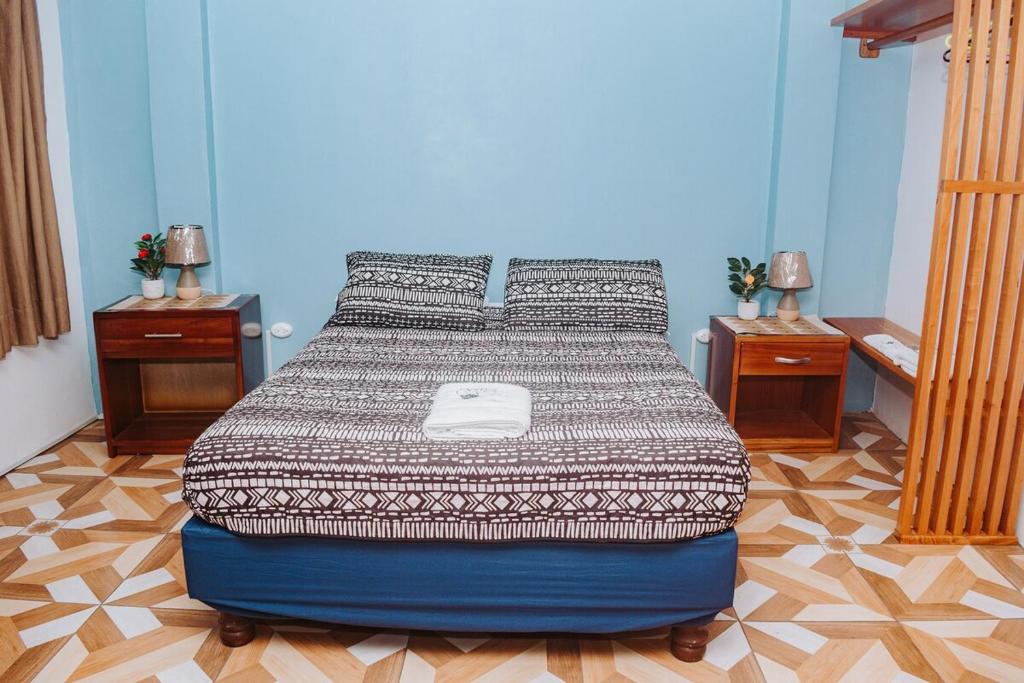 a bed in a room with two night stands and two tables at #5 Mini Suite, Cerca de Todo, 2-3 people - AC in Puerto Ayora