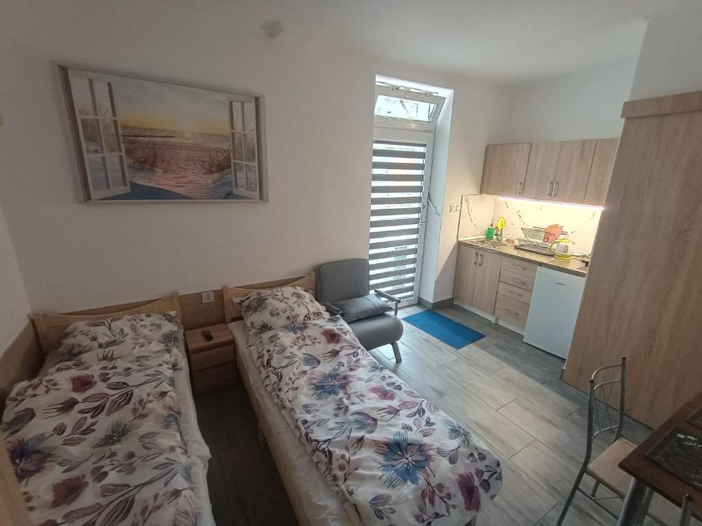 a small bedroom with a bed and a kitchen at u Oli Dawid Spaczyński in Mrzeżyno