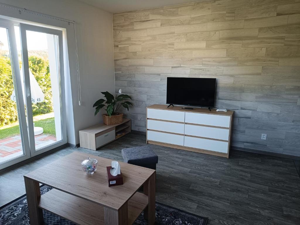 a living room with a tv and a table at Apartmán Velký Luh in Velký Luh