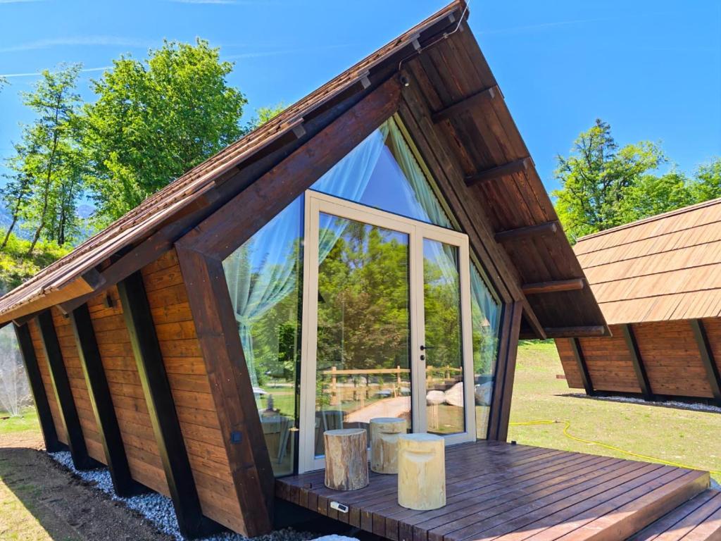 a small log cabin with a large glass window at Glamp Camp Danica in Bohinj