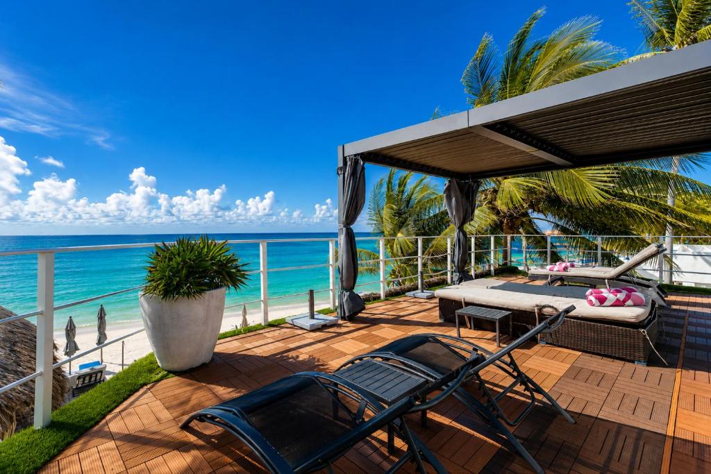 a deck with a bed and chairs on the beach at Luciana Hotel & Beach Club in Playa del Carmen