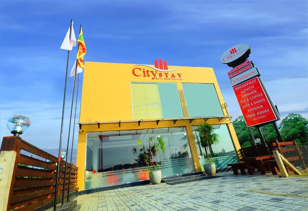 a yellow building with a sign in front of it at City Stay in Galle