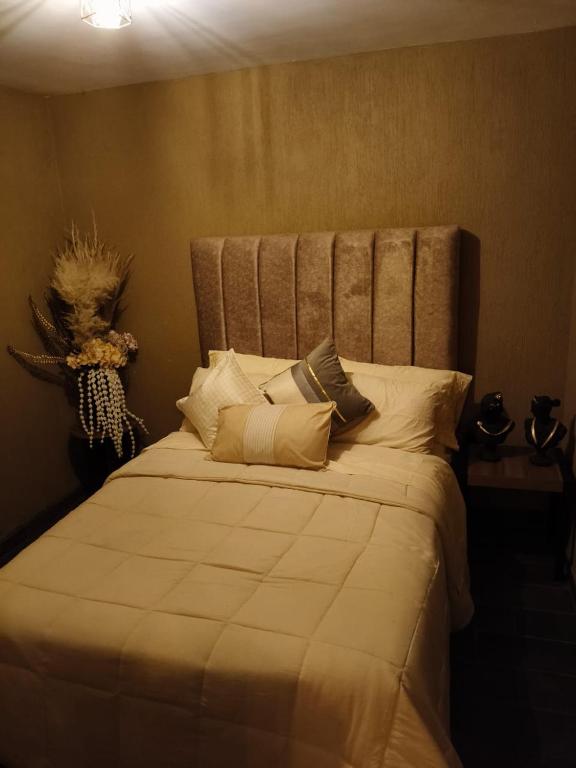a bedroom with a large bed with pillows on it at umbral luxury apartment in Tlajomulco