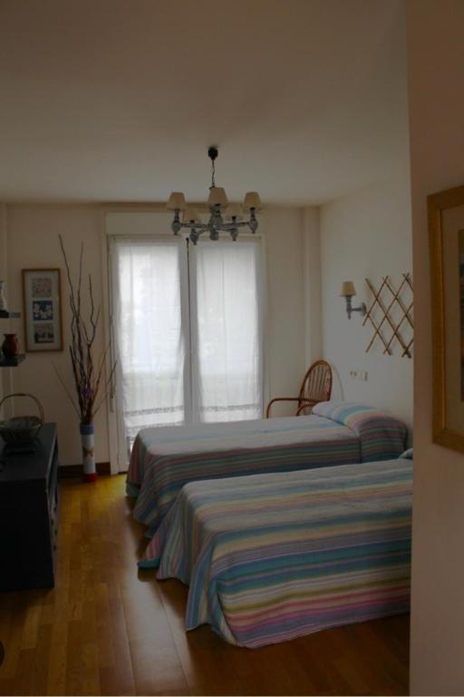 a bedroom with two beds and two windows at Ostatu ikaztegieta in Aldaba-chiqui