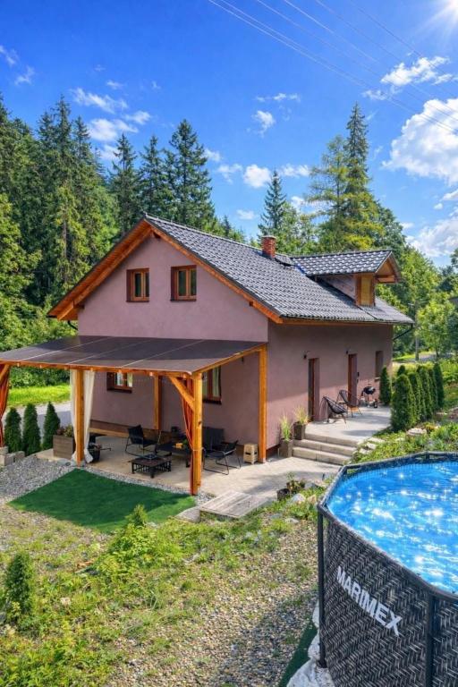 a house with a swimming pool in front of it at Casa NICOLE in Malá Morávka