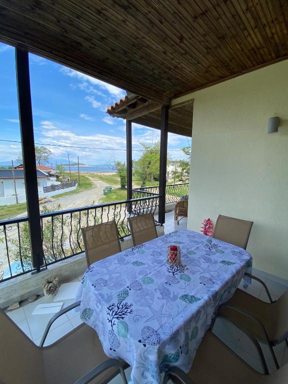 a dining room with a table and chairs on a balcony at Apostolis Seaside Living in Olympiada