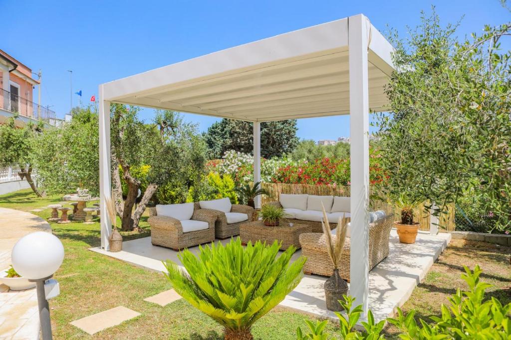 a white pavilion in a garden with trees at BeB Villa Pacifica in Peschici