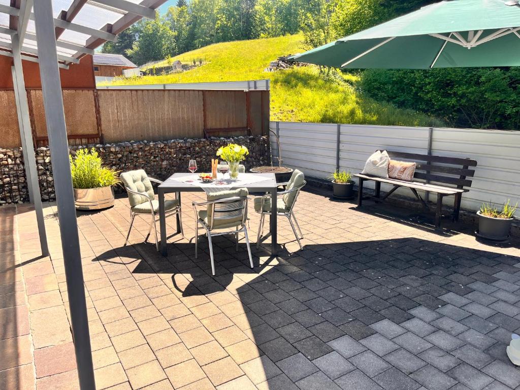 a patio with a table and chairs and an umbrella at Tiny Haus Dornbirn in Dornbirn