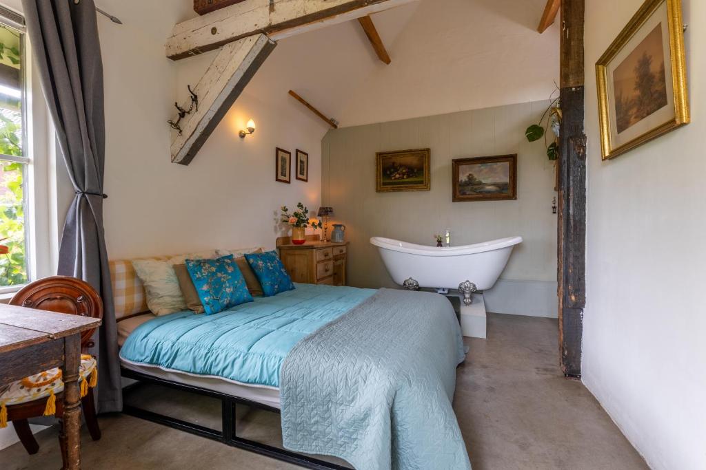 a bedroom with a bed and a bath tub at The Stables in Kampen