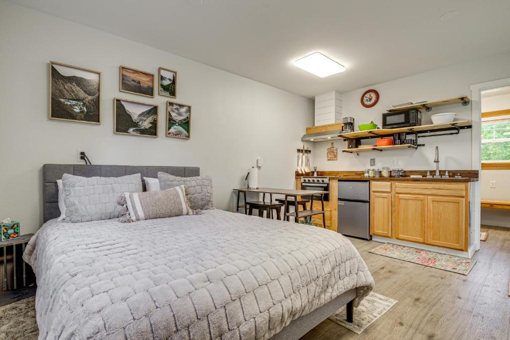 a bedroom with a large bed and a kitchen at Pet-Friendly Quaint Cottage: Park-Like Setting in Monroe