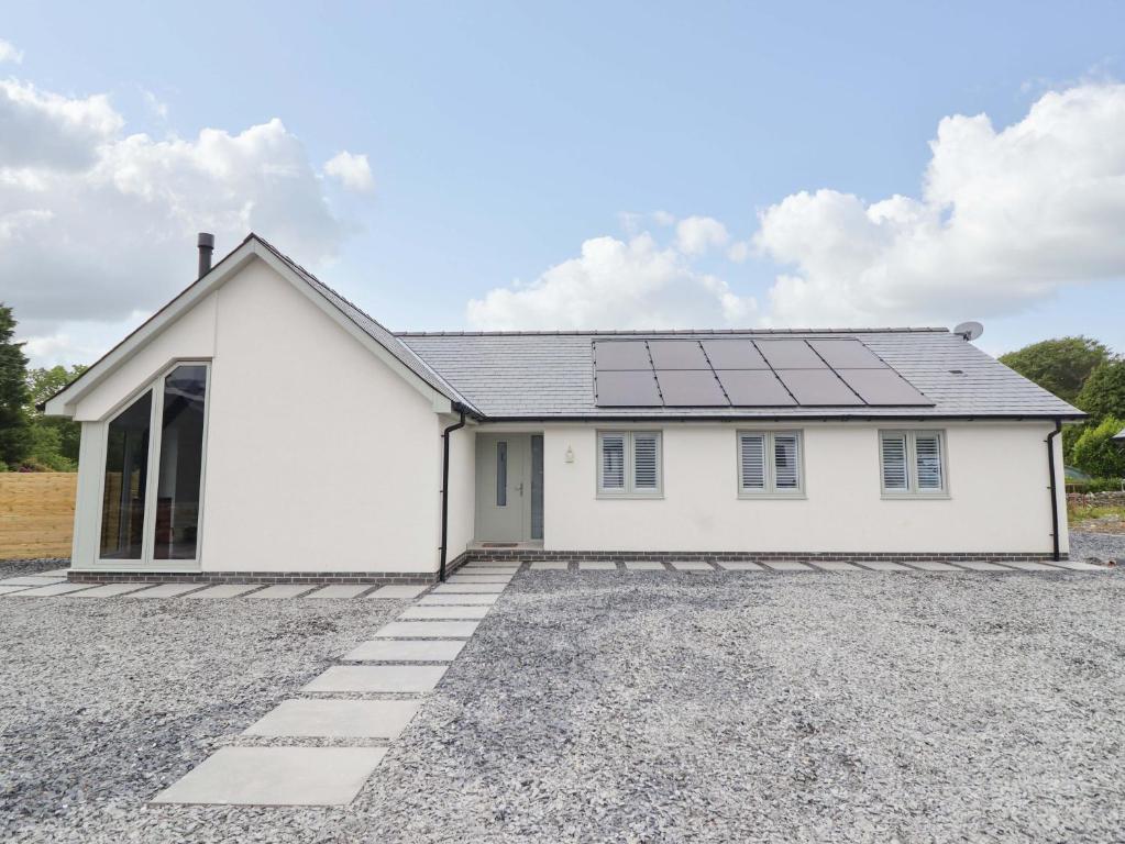 a white house with solar panels on the roof at Kingfisher in Talybont
