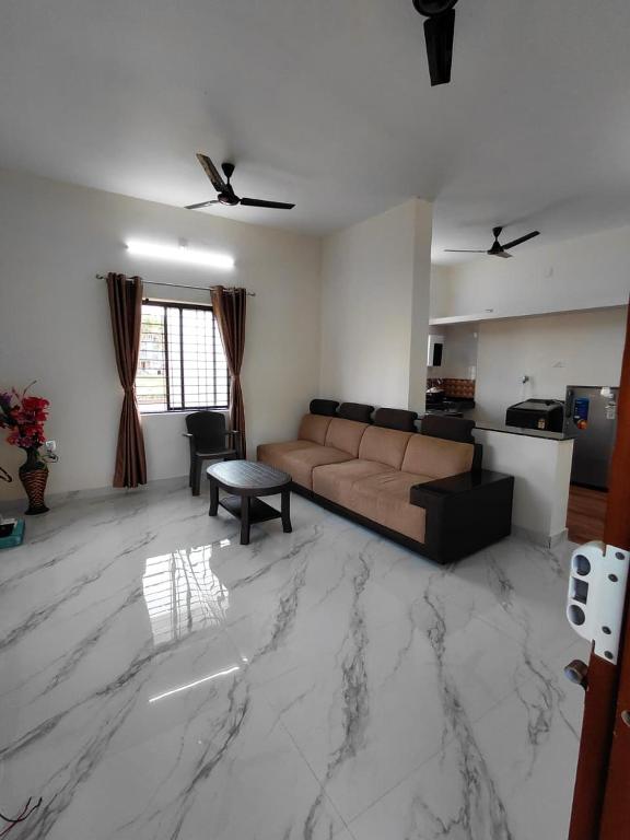 a living room with a couch and a marble floor at AGM Spacious Private AC 1BHK with Hall, Kitchen & Bath in Udupi