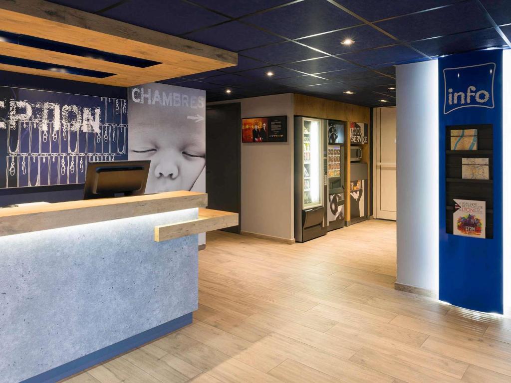 a lobby of a store with a laptop on a counter at ibis budget Lyon Centre Confluence in Lyon