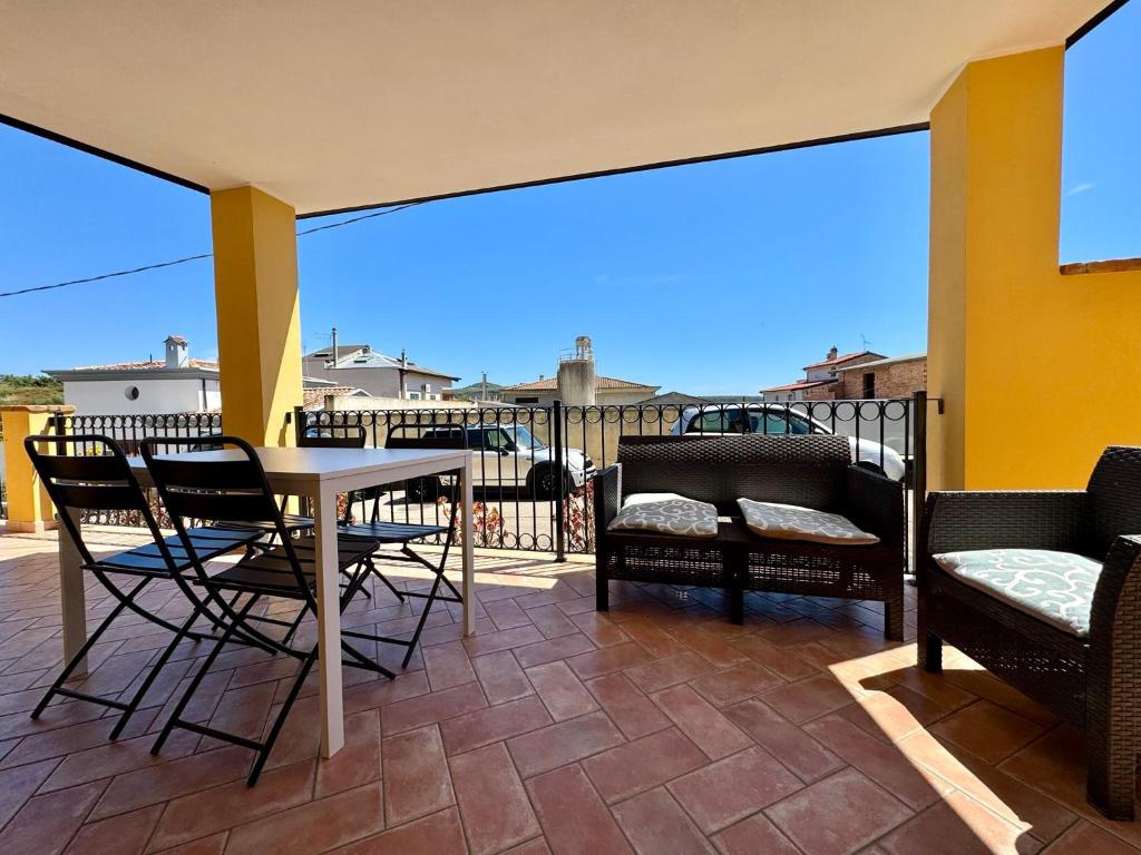 a patio with a table and chairs on a balcony at Orange House in Bari Sardo