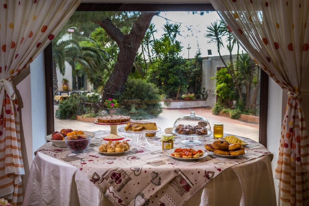 un tavolo con cibo sopra di esso davanti a una finestra di Agriturismo Fiori d'Arancio a Palagiano
