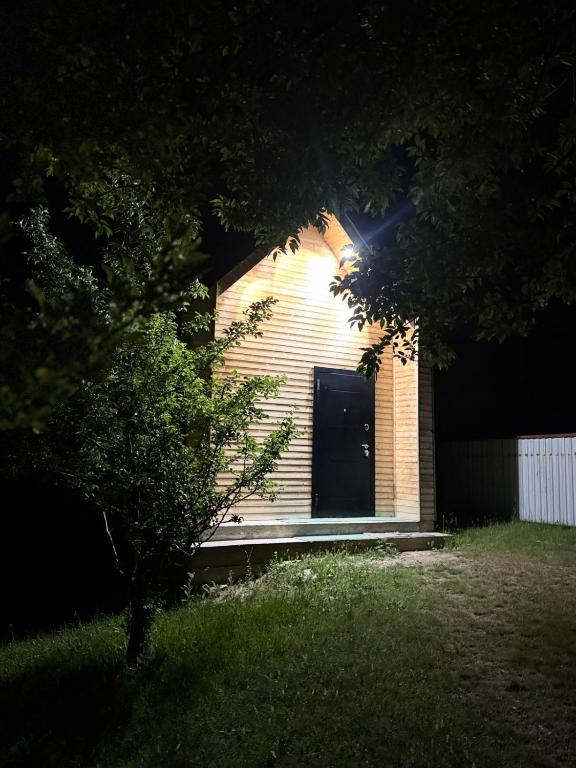 a small brick building with a black door at Perizat in Saty