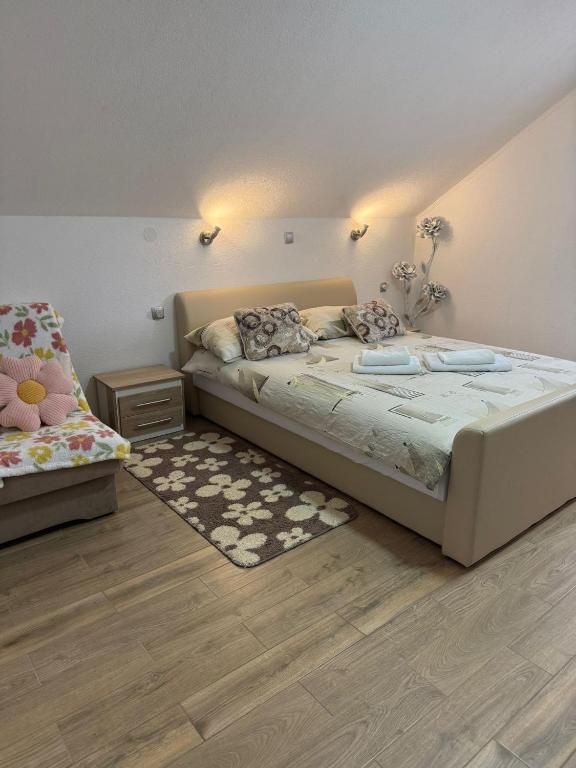 a bedroom with a large bed and a rug at Apartment Slap in Rakovica