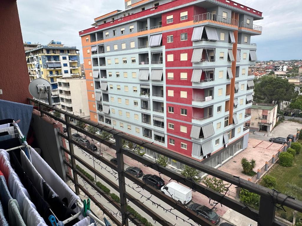 a red and white building in front of a city at Gorenje apartment in Fier