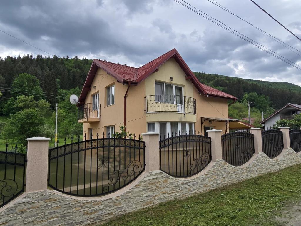 a house with a fence in front of it at Vila Pângărați in Pangarati