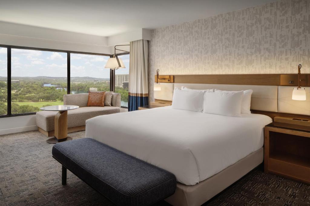 a hotel room with a large white bed and a couch at Hyatt Regency Austin in Austin
