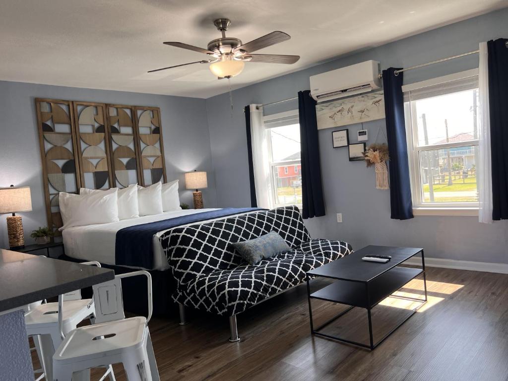 a bedroom with a bed and a couch and a table at The Mark at Surfside #8 in Surfside Beach